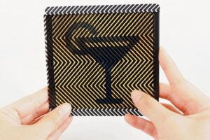 Manos sosteniendo una tarjeta con patrón óptico