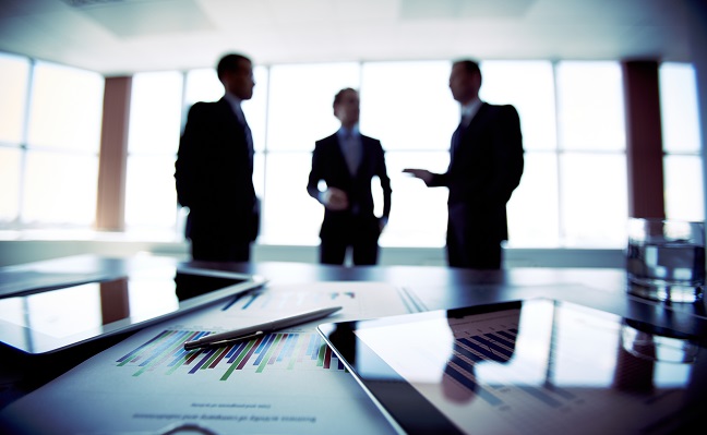 Tres profesionales discutiendo en una oficina moderna