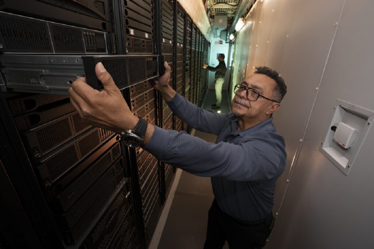 Técnico ajustando un componente en un superordenador de IA en Lincoln Lab.